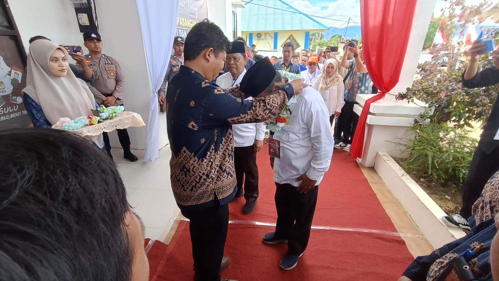 Ketua KPU Nunukan, Riko Ardianya mengalungkan Bunga Kepada Pasangan Calon Bupati dan Wakil Bupati Nunukan, H Basri - Hanafiah