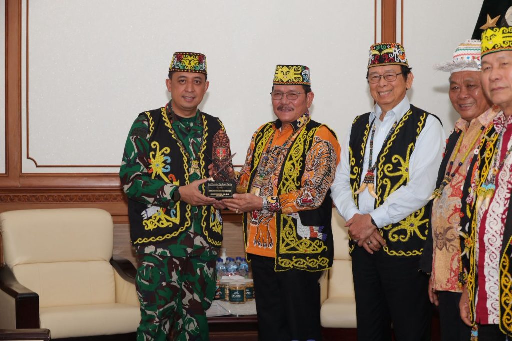 Wagub Audiensi dengan Pangdam Mulawarman, Bahas Generasi Dayak Kenyah Masuk TNI BALIKPAPAN – Harapan generasi muda Dayak Kenyah untuk mengabdi kepada negara melalui Tentara Nasional Indonesia (TNI) menjadi salah satu topik utama dalam pertemuan Wakil Gubernur (Wagub) Kalimantan Utara (Kaltara) Ingkong Ala, S.E., M.Si., dengan Pangdam VI/Mulawarman Mayjen TNI Krido Pramono, S.H., M.Si., di Markas Kodam VI/Mulawarman, Balikpapan, Senin (16/3). Dalam pertemuan itu, Wagub Ingkong yang juga menjabat Ketua Pengurus Lembaga Adat Dayak Kenyah Kalimantan Utara (LADKKU) hadir bersama Presiden Majelis Adat Dayak Nasional (MADN) Dr. Drs. Marthin Billa, M.M. Pertemuan berlangsung hangat. Selain mempererat silaturahmi, Ingkong menyampaikan berbagai aspirasi masyarakat adat Kaltara, khususnya terkait keamanan wilayah perbatasan dan masa depan generasi muda Dayak Kenyah. Menurut Ingkong, lembaga adat memiliki peran penting dalam menjaga harmoni masyarakat. Selain merawat nilai budaya, lembaga adat juga sering menjadi jembatan penyelesaian persoalan sosial di tengah masyarakat. Ia menilai kerja sama antara tokoh adat dan TNI sangat penting, terutama karena Kaltara merupakan daerah perbatasan yang memiliki posisi strategis. “Kami berharap ada kolaborasi yang kuat antara tokoh adat dan TNI untuk menjaga keamanan wilayah sekaligus memperkuat semangat kebangsaan masyarakat,” kata Ingkong. Dalam kesempatan itu, ia juga menyampaikan bahwa minat generasi muda Dayak Kenyah untuk menjadi prajurit TNI cukup tinggi, khususnya melalui jalur Akademi Militer (Akmil). Namun, anak-anak muda dari daerah pedalaman masih menghadapi berbagai kendala, mulai dari kurangnya akses informasi tentang proses seleksi hingga minimnya pembinaan awal untuk mempersiapkan diri. Karena itu, Ingkong berharap Kodam VI/Mulawarman dapat membantu membuka akses yang lebih luas melalui sosialisasi penerimaan prajurit TNI hingga ke wilayah pedalaman Kaltara. “Kalau ada pembinaan sejak awal dan informasi yang lebih terbuka, saya yakin banyak putra-putri daerah yang bisa bersaing dan mengabdi kepada negara,” ujarnya. Ia berharap pertemuan ini menjadi langkah awal memperkuat hubungan antara TNI dan masyarakat adat, sekaligus membuka jalan bagi generasi muda Kaltara untuk ikut berperan dalam menjaga kedaulatan negara. (dkisp)