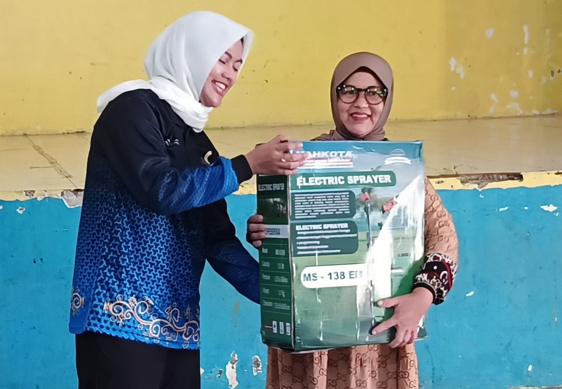 Ketua HKTI Nunukan, Hj Asmin Laura Hafid SE, MM, Ph.D menyerahkan hadiah Handsprayer ke petani.