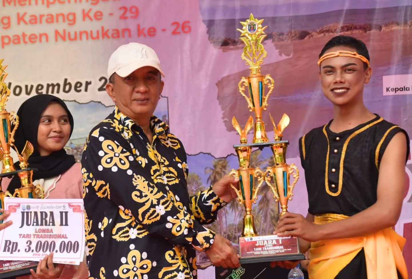 Peringati HUT Desa Tanjung Karang, Warga dan Pemkab Nunukan Satu dalam Semangat Kebersamaan Nunukan – Pemerintah Kabupaten Nunukan bersama masyarakat Desa Tanjung Karang, Kecamatan Sebatik, merayakan Hari Ulang Tahun (HUT) Desa Tanjung Karang ke-29 yang berlangsung meriah di Pantai Batulamampu, Minggu (2/11/2025). Kegiatan ini juga dirangkaikan dengan peringatan HUT Kabupaten Nunukan ke-26 tahun 2025 yang dikemas dengan suasana penuh keakraban dan kebersamaan. Mewakili Bupati Nunukan, Asisten Pemerintahan dan Kesejahteraan Rakyat (Kesra) H. Abdul Munir, ST., M.AP., hadir dan menyampaikan ucapan selamat ulang tahun kepada seluruh masyarakat Desa Tanjung Karang. Ia berharap momentum ini menjadi dorongan untuk meningkatkan semangat membangun desa yang lebih maju, mandiri, dan sejahtera. “Semoga dengan bertambahnya usia, Desa Tanjung Karang semakin berkembang di berbagai sektor dan selalu bersinergi dengan pemerintah daerah dalam mewujudkan kesejahteraan masyarakat,” ujar H. Abdul Munir saat membacakan sambutan Bupati Nunukan. Suasana perayaan tampak semarak dengan kegiatan karnaval dan acara bakar ikan bersama di sepanjang pesisir Pantai Batulamampu. Sebanyak 150 kilogram ikan hasil tangkapan nelayan disiapkan oleh Kepala Desa Tanjung Karang, Faisal, untuk dibagikan kepada masyarakat dan tamu undangan. Tradisi bakar ikan ini menjadi simbol kebersamaan serta mempererat tali persaudaraan antarwarga Sebatik. Kepala Desa Tanjung Karang, Faisal, menyebut kegiatan tersebut bukan sekadar perayaan, tetapi juga ajang memperkuat persatuan dan gotong royong. Ia mengapresiasi partisipasi seluruh warga yang antusias menyukseskan acara hingga berjalan lancar dan penuh kehangatan. Dalam sambutannya, Bupati Nunukan juga mengajak seluruh elemen masyarakat untuk terus menjaga kekompakan dan kerukunan antarwarga, termasuk antara aparat desa dengan masyarakat. Menurutnya, kebersamaan menjadi kunci dalam mendorong kemajuan desa. “Salah satu wujud nyata kebersamaan adalah gotong royong. Jika kita lakukan bersama, yang berat akan terasa ringan dan yang sulit akan menjadi mudah,” pesan Bupati dalam sambutan yang dibacakan oleh H. Abdul Munir. Acara tersebut turut dihadiri para camat se-Pulau Sebatik, Forkopimcam, Ketua TP2D Kabupaten Nunukan, perwakilan UPTD Dinas Pendidikan Kalimantan Utara, tokoh adat, dan tokoh masyarakat. Kehadiran berbagai pihak ini menunjukkan semangat kolaborasi dan kebersamaan antara pemerintah dan masyarakat dalam membangun daerah perbatasan yang lebih baik.